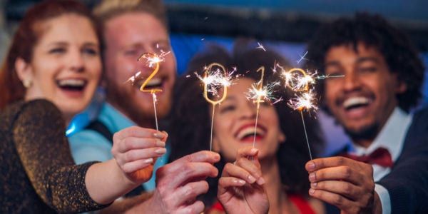 Smiling people holding 2019 sparklers