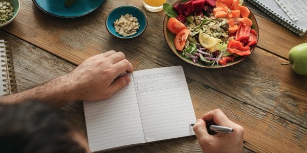 Man writing in food journal