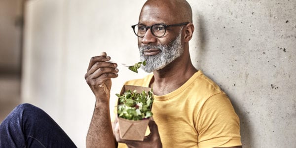 Mature businessman having lunch break eating a salad