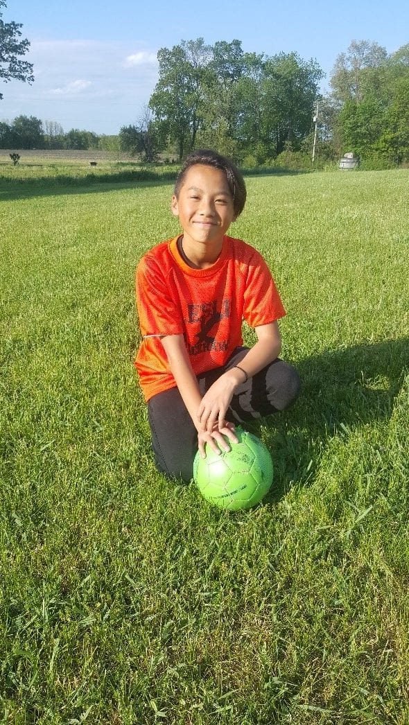I nice day with Logan Yang in a field with a green soccer ball