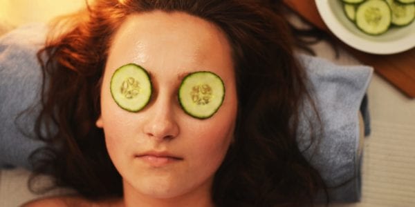 Woman with cucumber slices on eyes for a face mask.