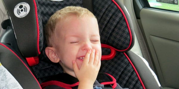 Child laughing in his car seat.