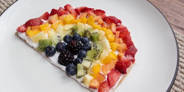 Fruit rainbow pizza on a plate.