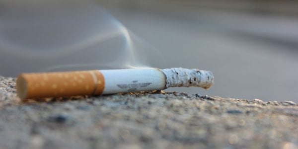 closeup of a partially smoked cigarette on the ground.