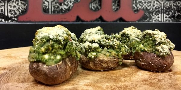 Spinach and feta stuffed mushrooms are displayed on a serving tray