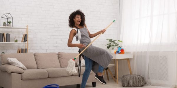 Woman dancing cleaning her apartment