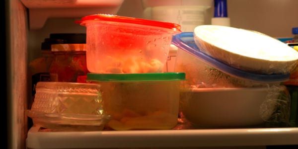 Image of leftovers stacked messily in the fridge.