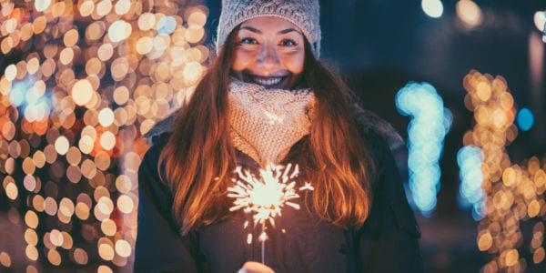 Happy woman at Christmas holding burning sparkler