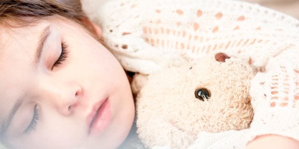 Child sleeping with stuffed animal