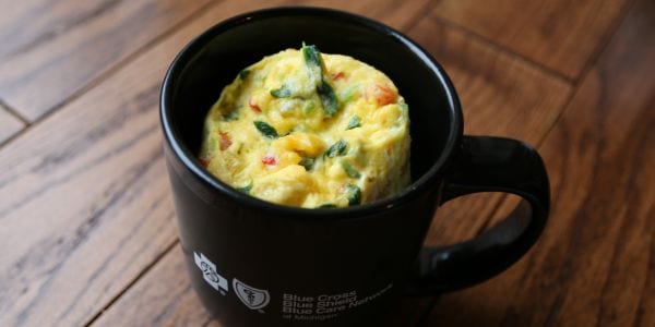 Spinach, bell pepper, onion omelet in a black mug
