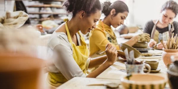 Young women at a table working on pottery