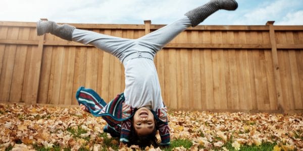 Little girl doing cartwheels in the leaves