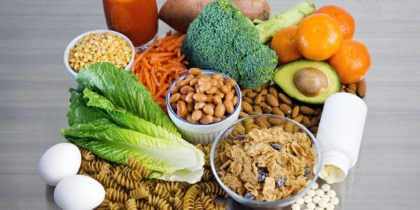 Folic acid foods including beans, pasta, cereal, avocado and broccoli sit on a table