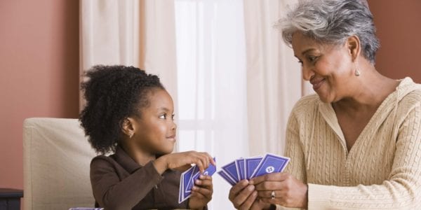 Grandmother playing cards with granddaughter