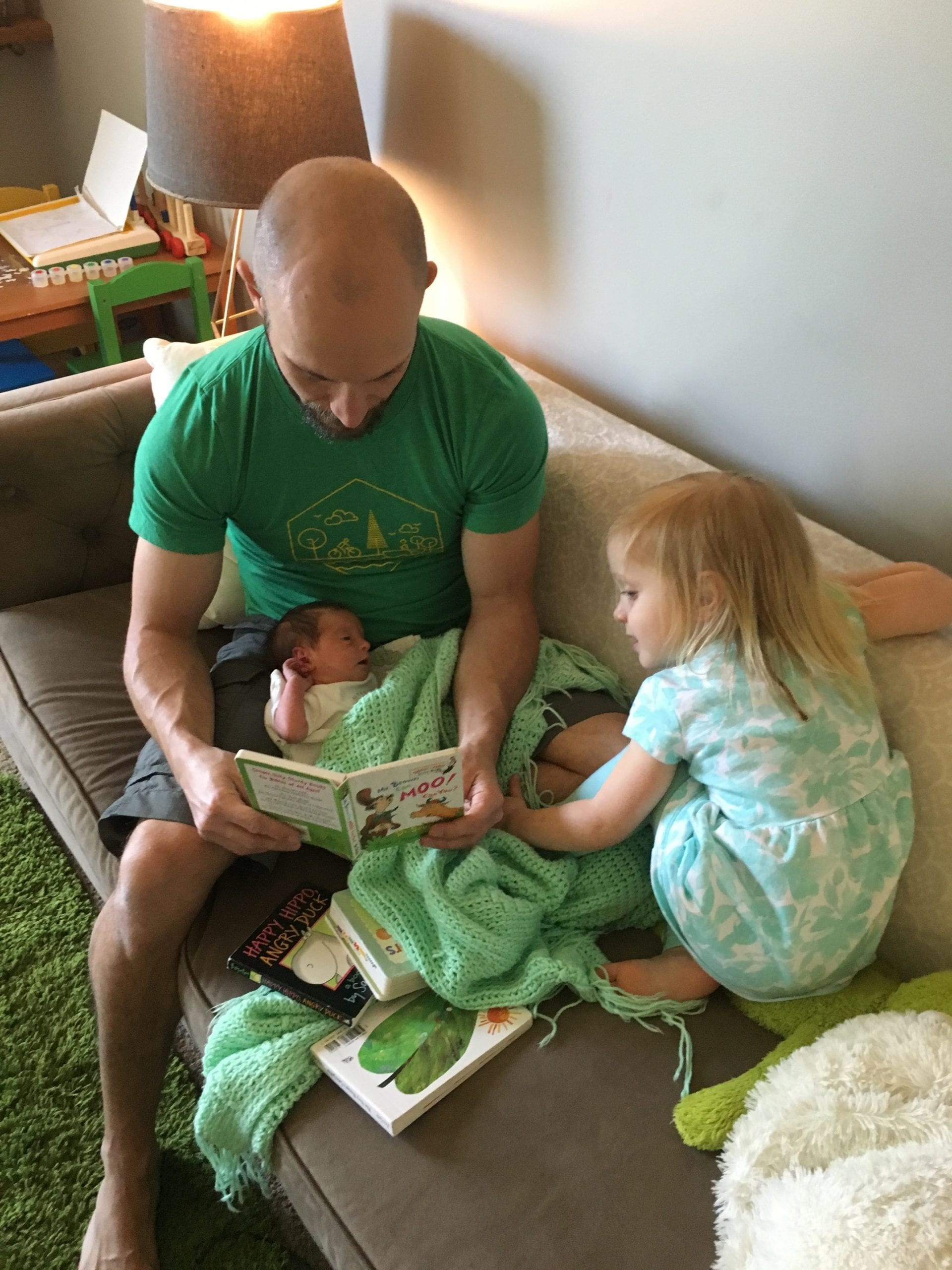 Dad reading to his two young daughters
