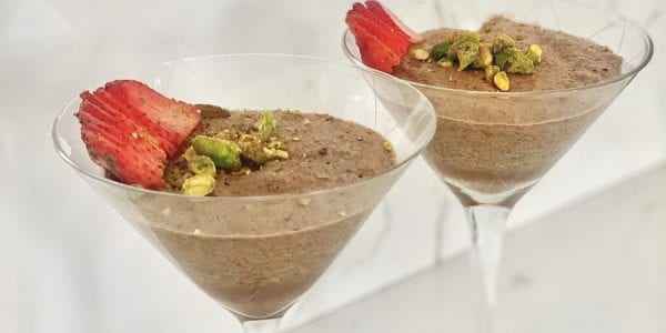 Chocolate mousse in dessert glasses topped with strawberries