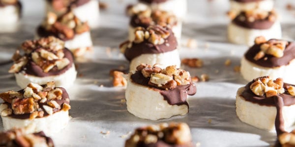 Banana slices covered with chocolate and nuts