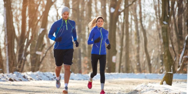 Couple in winter running together in nature