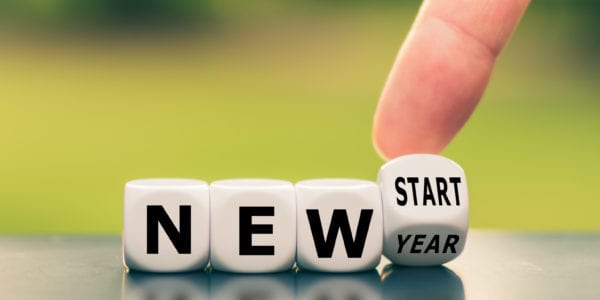 Hand turns a dice and changes the expression "new year" to "new start".