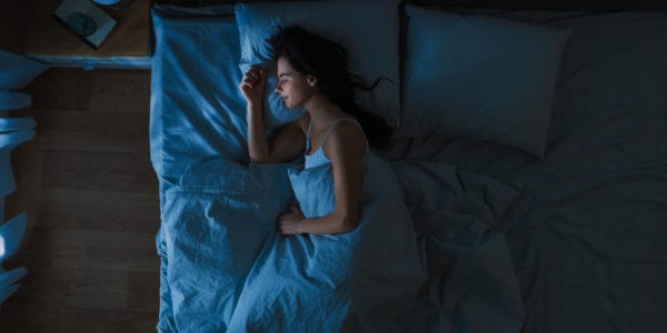 Woman sleeping on her side in bed