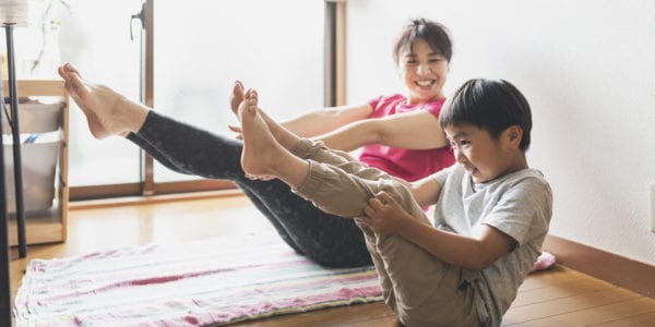 Asian mother and son exercising in the living room.