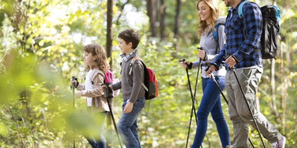 Happy Family with two children hiking outdoors. Enjoy beautiful day in nature. Shallow DOF