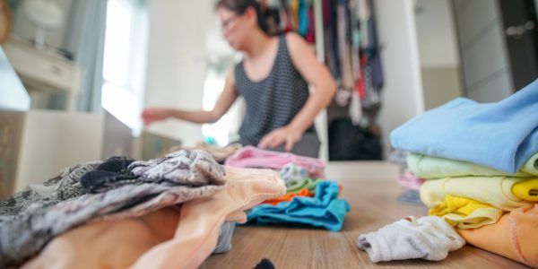 Woman folds and sorts laundry to declutter her room
