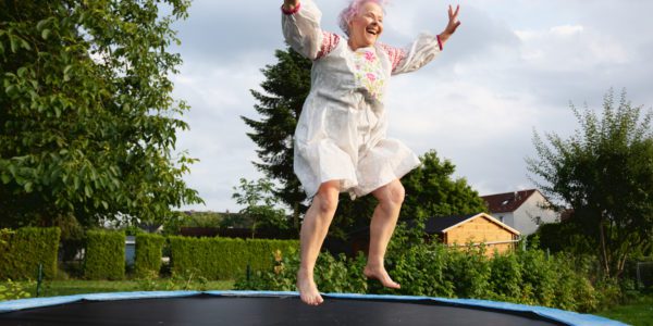 Senior woman with overweight jumping on trampoline