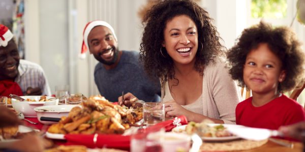 A family sits together and enjoys a meal during the holidays.