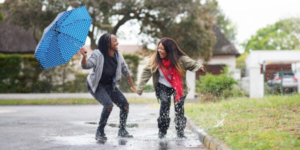 Two teenagers have fun playing in the rain.