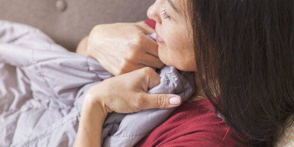 Woman relaxing on couch with weighted blanket